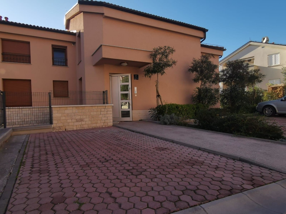 Kilátás a parkolóra és az épület bejáratára Crikvenicában.