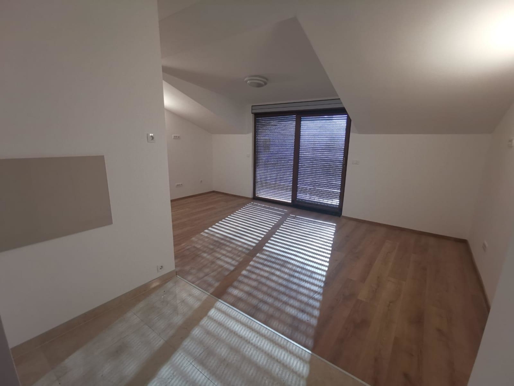 Kilátás a konyhából a nappali-étkezőre, kijárattal a tetőtérben található erkélyre.