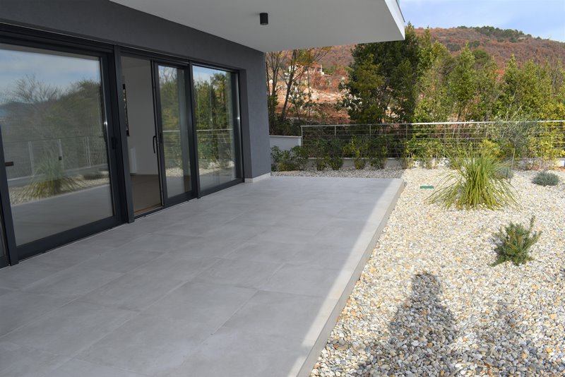 Egy ablakos hálószoba egy parkettás, légkondicionált apartmanban.