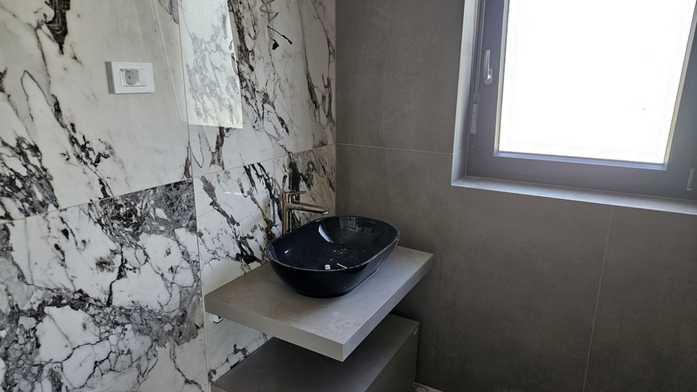 A modern fürdőszoba márványlapokkal a falon.