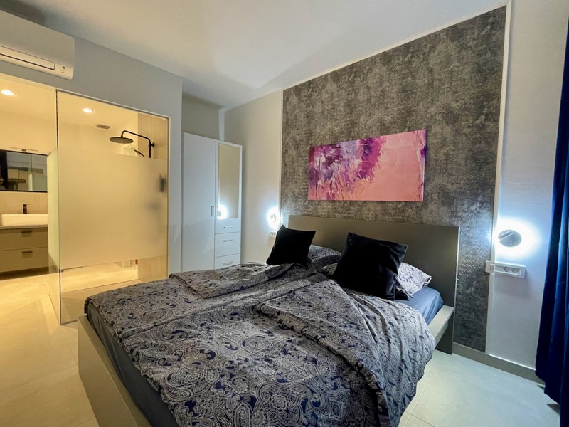 A horvátországi Zadarban eladó lakás belső nézete üveg zuhanyparavánnal és világos szoba kilátással