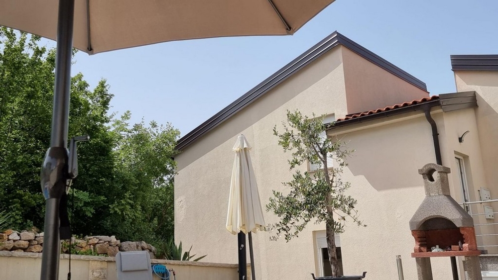 Kilátás az épületre és a lakás grillezőjére.