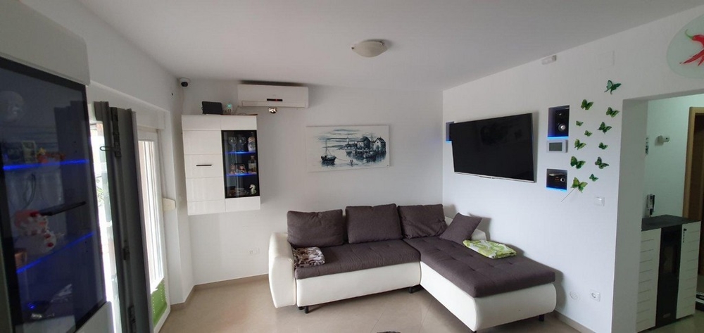 Hangulatos, bútorozott nappali kanapéval és légkondicionálóval.