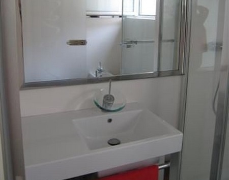 Mosdó és zuhanyzó üvegfallal.