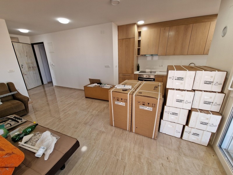 Modern nappali nyitott koncepcióval és konyhával.