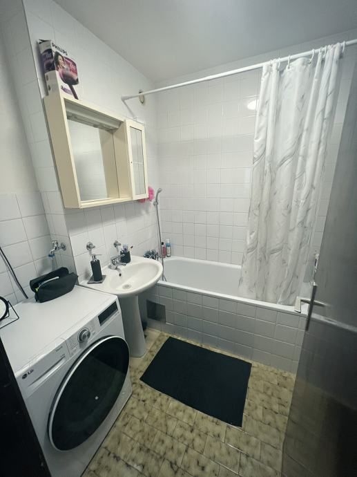 Fürdőszoba mosógéppel és káddal.