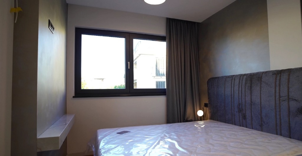 Egyszerű hálószoba tengerre néző kilátással egy horvát tengerparti ingatlanban, minimalista berendezéssel.