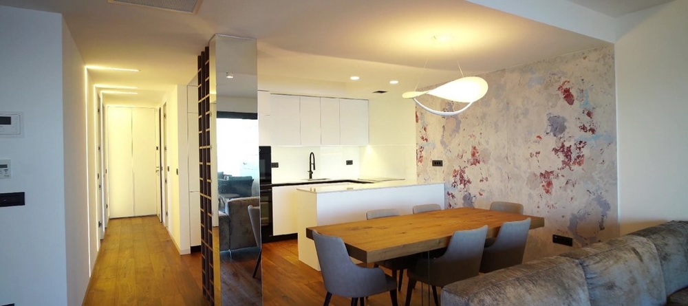 Tágas nappali és étkező egy horvát tengerparti ingatlanban, minimalista dizájnnal.