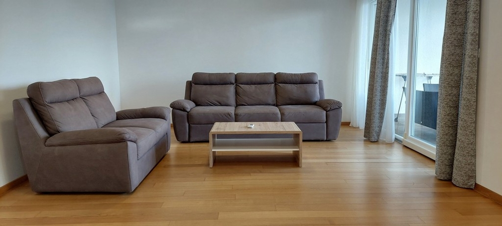 Hangulatos nappali modern kanapékkal és kijárat a teraszra Opatija ingatlanban.