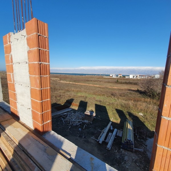 Új lakások építése a horvátországi Privlakában, kilátással a tengerre a háttérben.