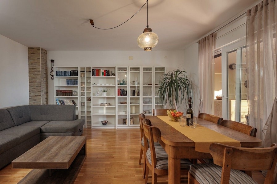 Nappali és étkező könyvespolccal és nagy asztallal a horvát ingatlanban.