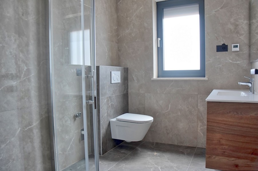 Elegáns fürdőszoba egy isztriai penthouse-ban, falra szerelhető WC-vel és mosdóval.