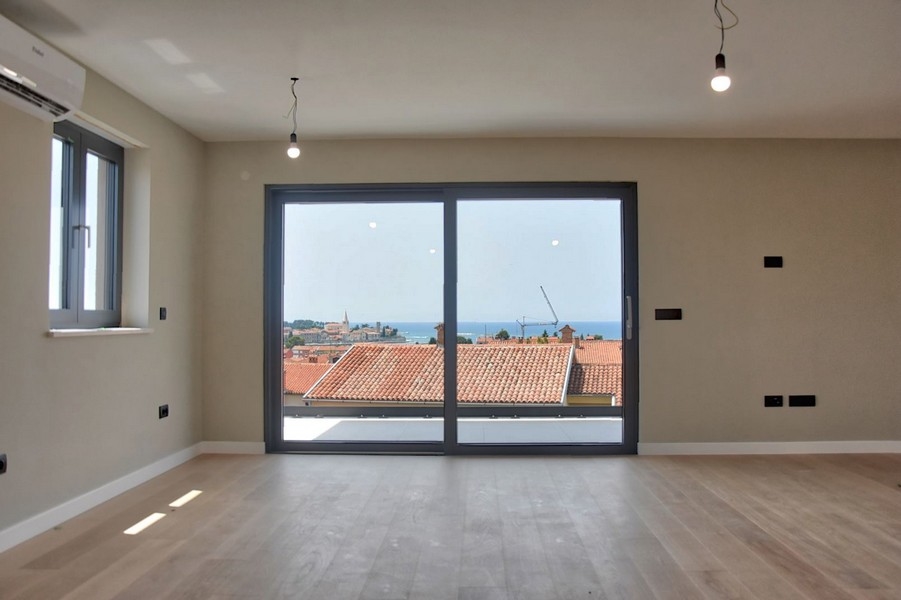 Nyitott terű nappali fapadlóval, kilátással az isztriai tetőkre, egy penthouse része eladó.