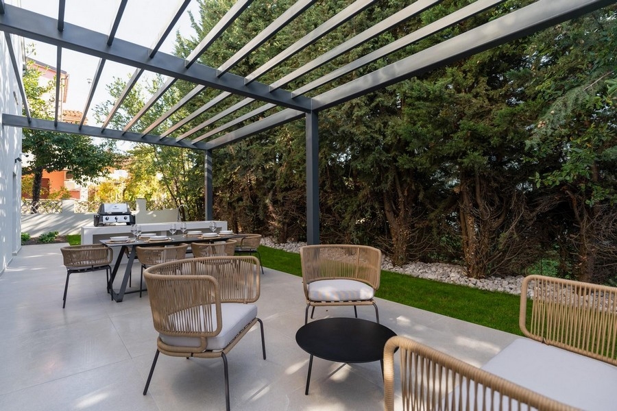 Nyári konyhával és étkezővel ellátott terasz külső kilátása az isztriai luxuslakásban, zöldövezetben