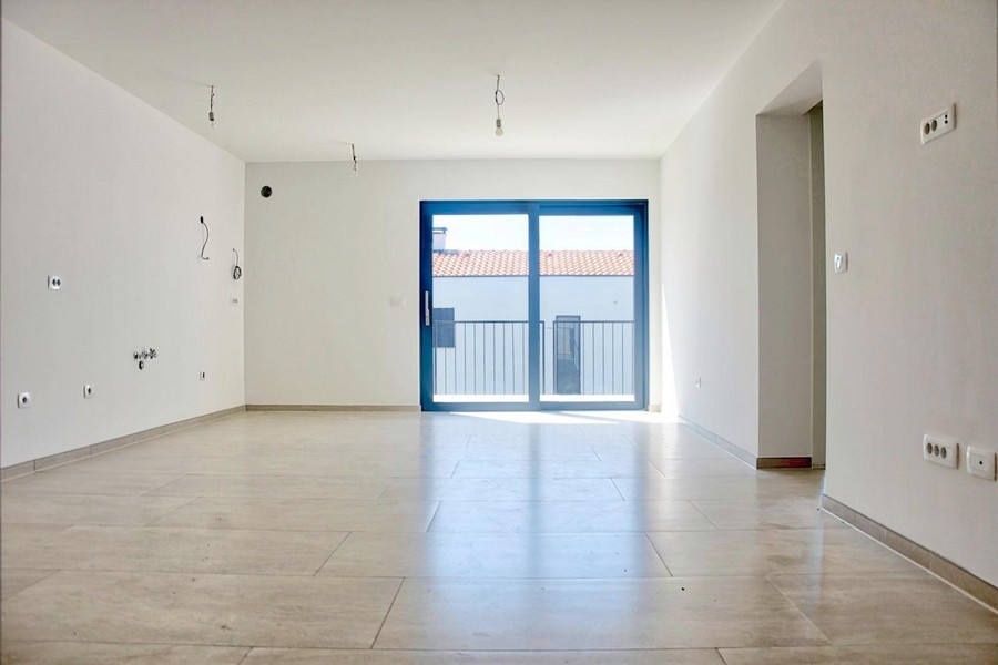 Üres világos nappali nagy francia ablakokkal és járólapozott padlóval, ingatlan kínálat Porecen