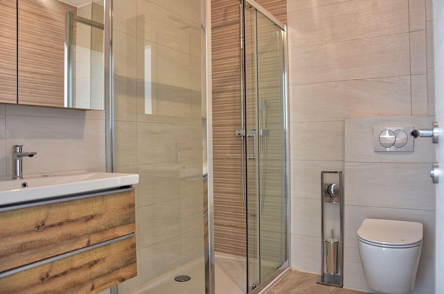 Modern fürdőszoba üvegzuhannyal és fa díszítéssel, Porečben található ingatlan