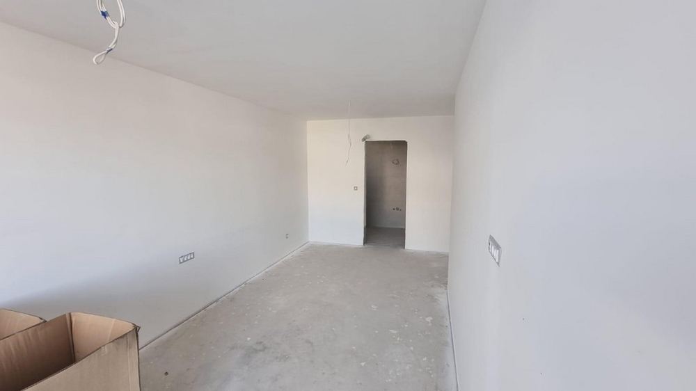 Egy horvátországi lakás üres szobája világos falakkal és betonpadlóval.