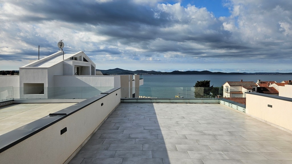Eladó egy penthouse tetőterasz Zadarban, Horvátországban, tengerre néző kilátással és felhős égbolttal