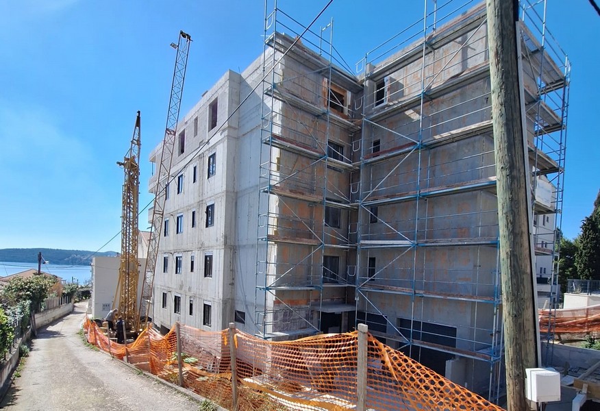 Egy épülő bérház hátulnézete horvátországi állványzattal és daruval, a Panorama Scouting