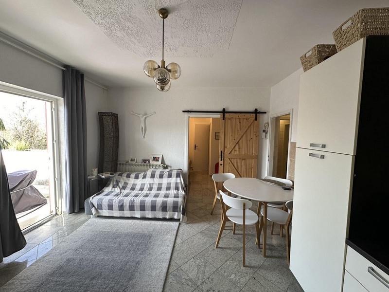 Nappali és hálószoba kanapéval és étkezőasztallal, ingatlan eladó a horvátországi Tisnóban