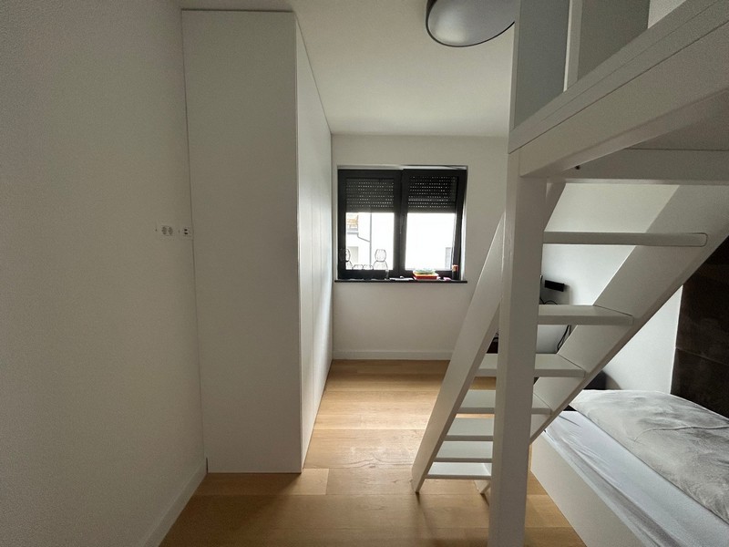 Második hálószoba tetőtéri ággyal és dolgozósarokkal egy modern apartmanban Rijekában, Horvátországban.