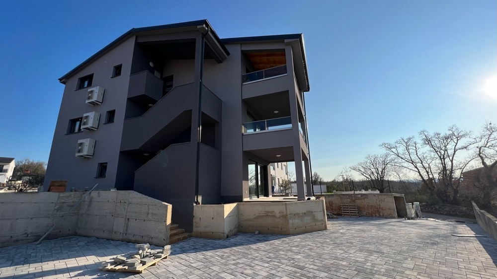 Egy új lakóépület oldalsó külső perspektívája Krk szigetén, a horvátországi ingatlanok ékköve.