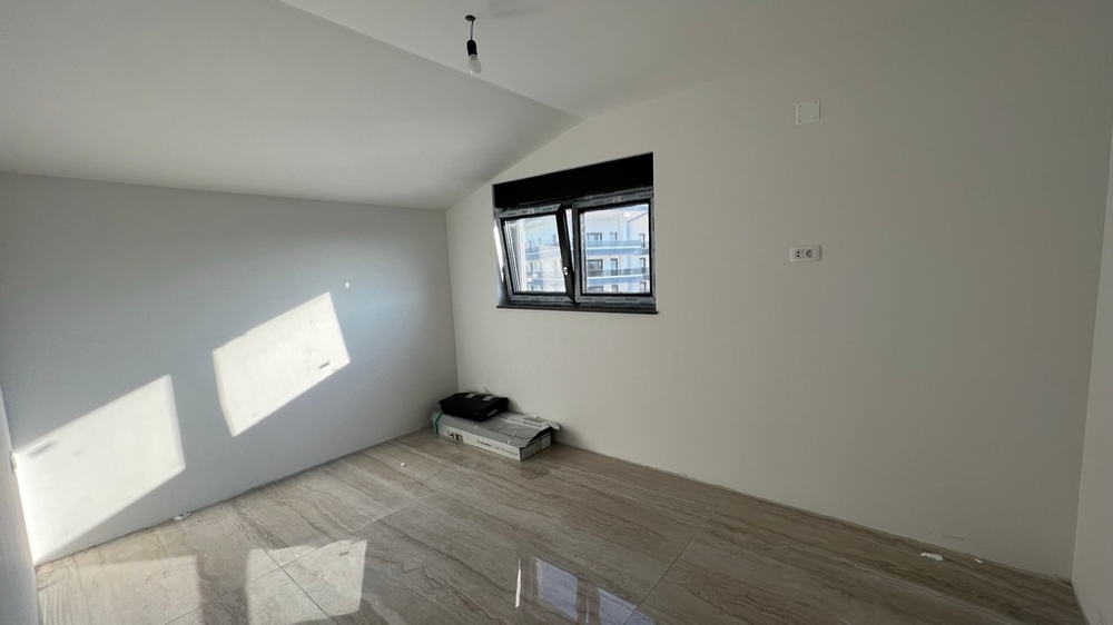 Minimalista kialakítású nappali világos járólappal, modern horvátországi ingatlanokhoz.