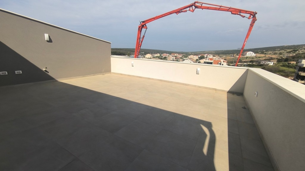 Ingatlan Horvátországban: Nagylátószögű felvétel egy penthouse teraszáról, Horvátország ingatlan tengerre néző kilátással és részleges kilátással egy vörös darura.