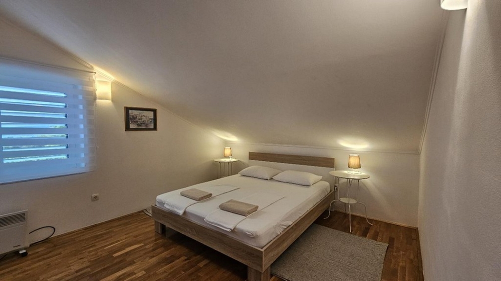 Hálószoba franciaággyal és meleg fapadlóval egy horvát ingatlanban, barátságos és kényelmes