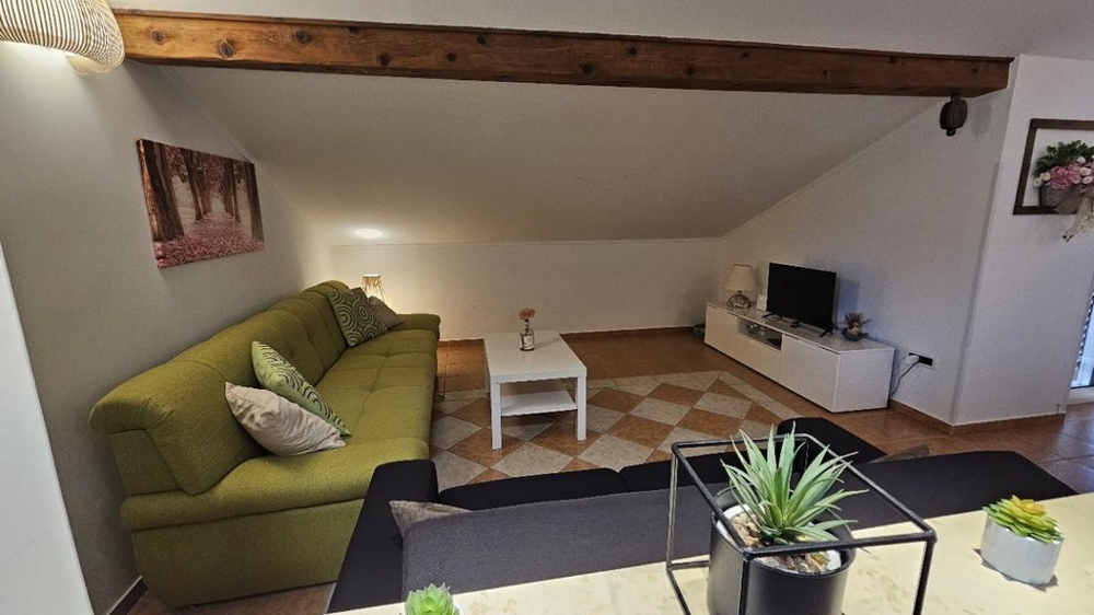 Hívogató, nagy nappali gerendákkal és kényelmes ülőhelyekkel egy horvátországi ingatlanban