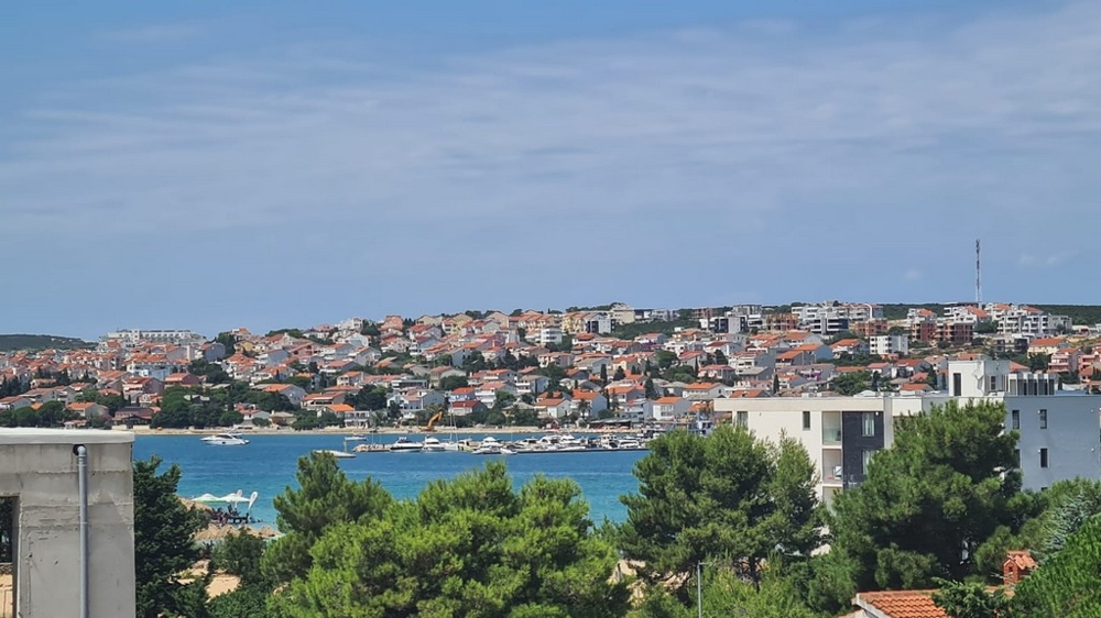 Panorámás kilátás Novaljára, Pag szigetére, kilátással az apartmanokra és a kék tenger partjára, Horvátország ingatlan