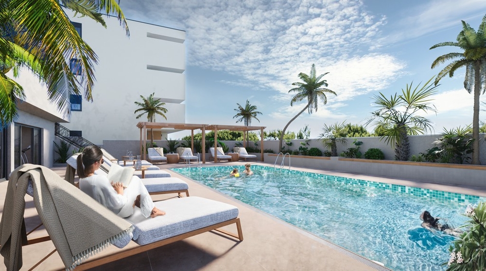 Ingatlan Horvátországban, Makarskában, tengerre néző apartman: Nő könyvet olvas egy nyugágyon a medence mellett, pálmafákkal körülvéve és nézi a tengert