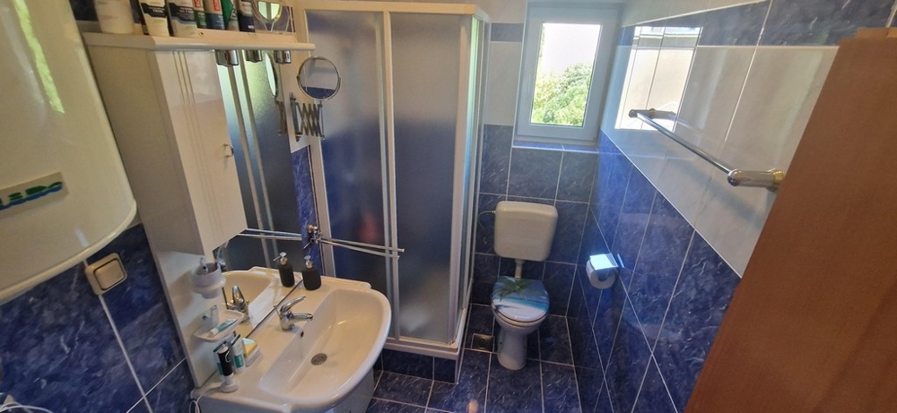 Fürdőszoba zuhanyzóval és modern járólappal