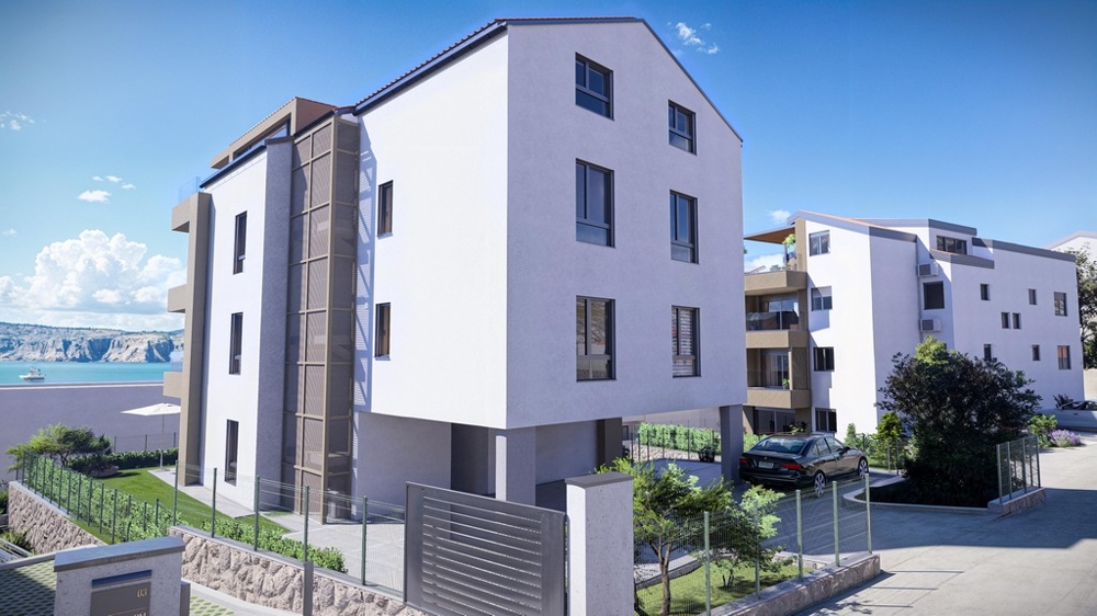 Modern többszintes tengerparti lakóépület tengerre néző kilátással és kövezett parkolóval