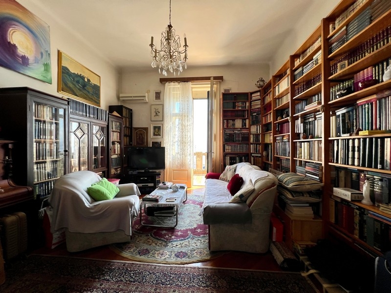 Apartman nagy és magas könyvespolcokkal.