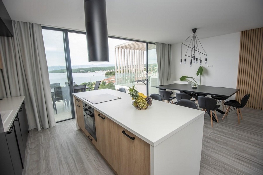 Modern konyha étkezőasztallal és kilátással a tengerre.