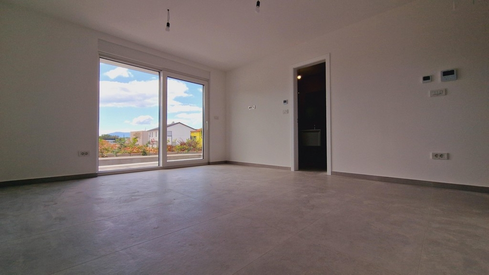 Világos szoba nagy ablakokkal és kilátással a kertre