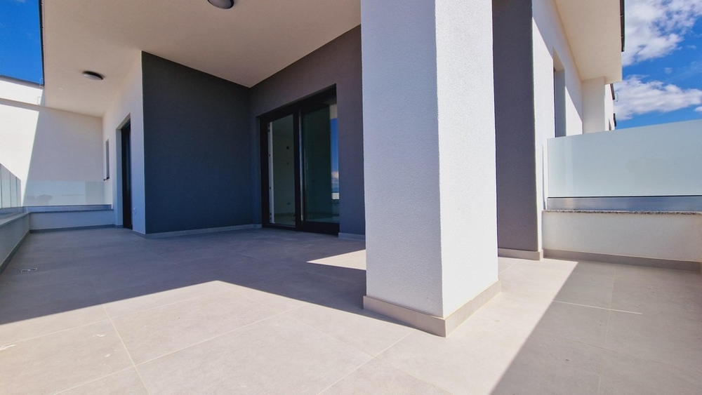 Nagy, modern terasz fehér oszlopokkal és üvegkorlátokkal