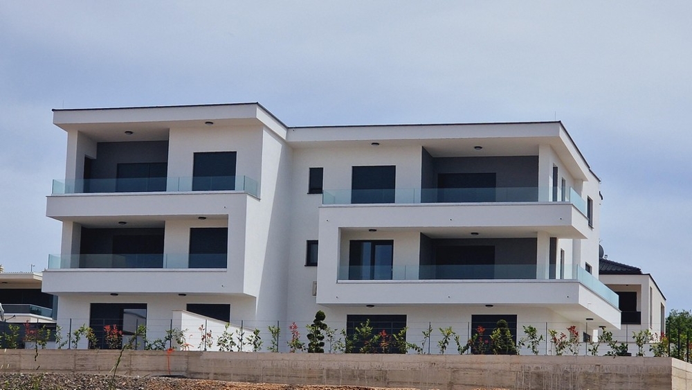 Modern, háromszintes lakópark erkéllyel és üvegkorlátokkal