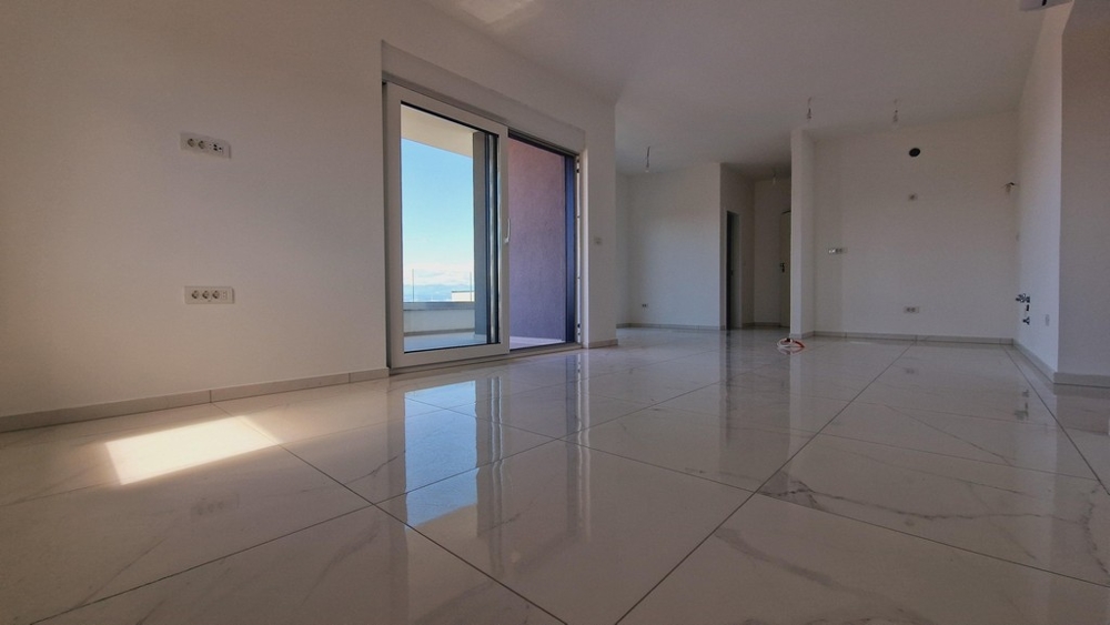 Nyitott nappali nagy ablakokkal és világos csempével