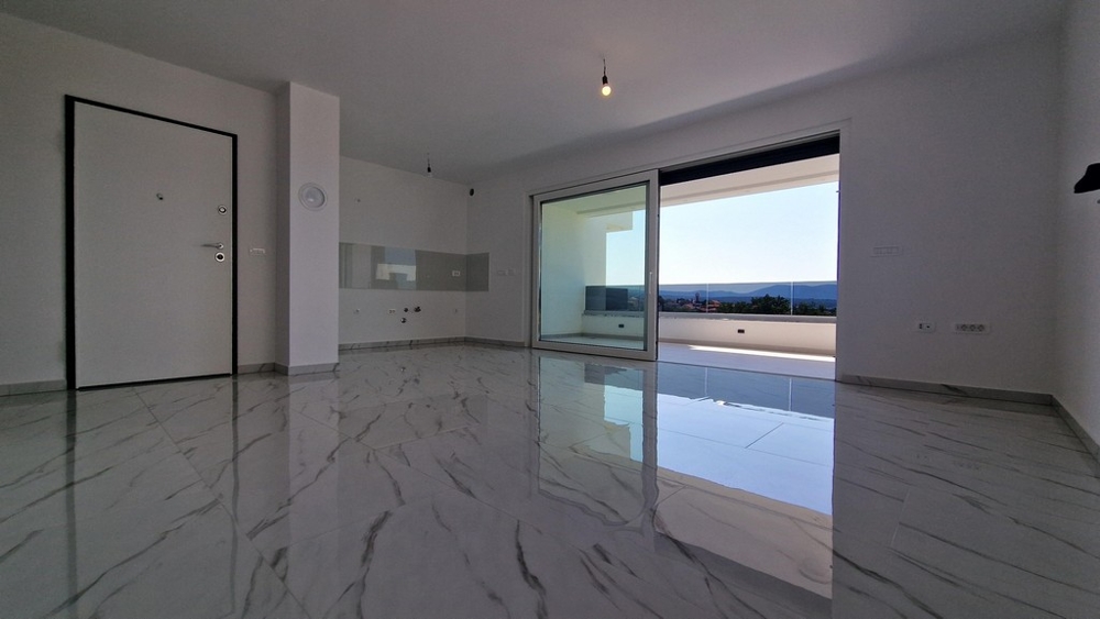 Teraszra és tengerre néző nappali, nagy tolóajtók.