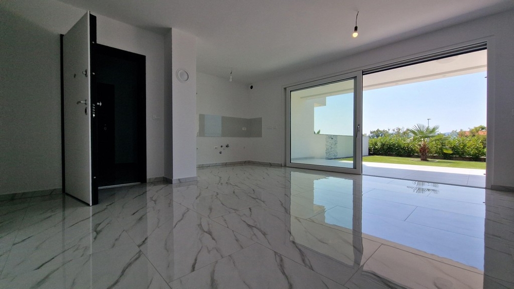 Nyitott terű nappali nagy ablakokkal a teraszra.