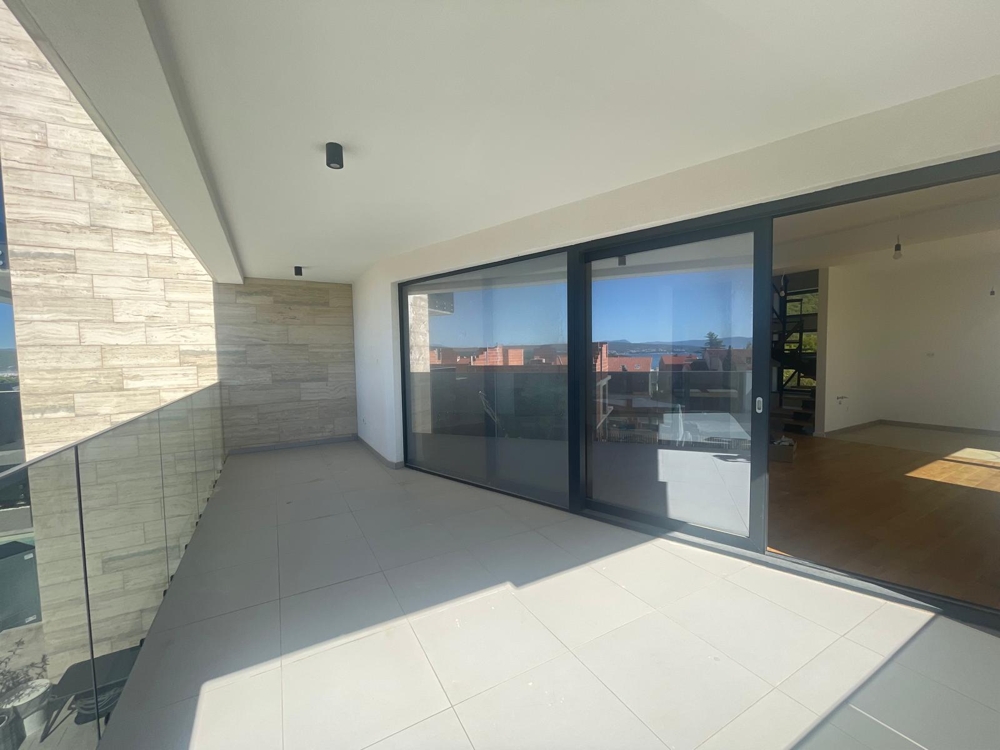 Belső nagy ablakkal és üvegajtókkal, kilátással a teraszra és a tengerre, a szoba befejezetlen állapotban