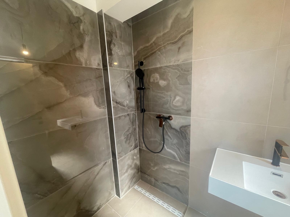 Tágas, befejezetlen szoba nagy ablakokkal és fehérre festett falakkal