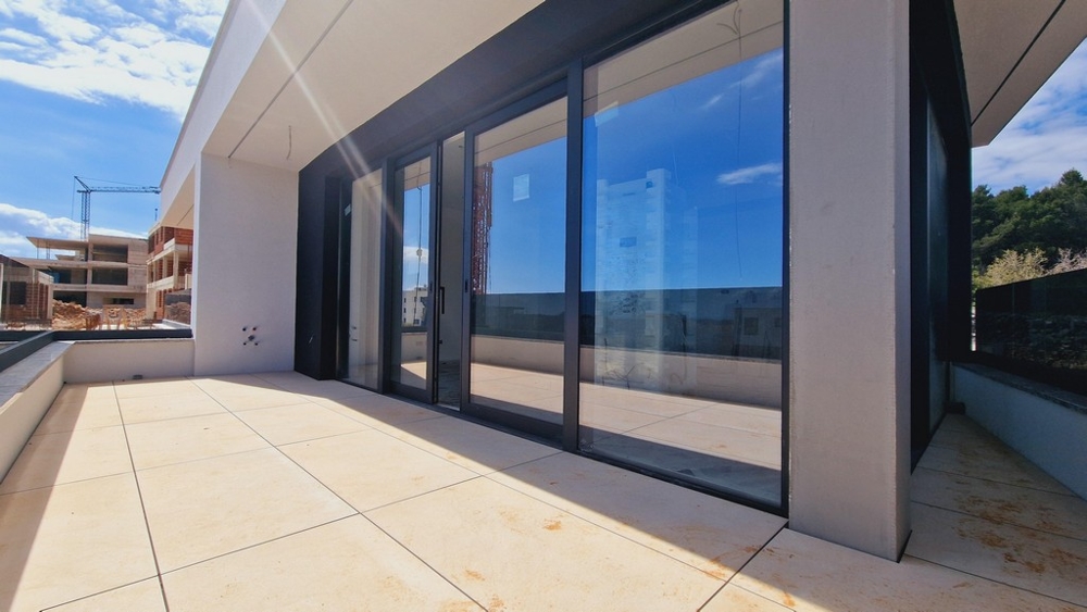 A Krk régióban található A3419 ingatlan nagy terasza üveg tolóajtókkal.