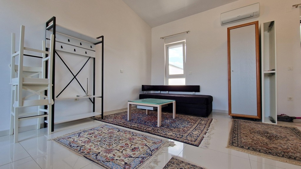 Nappali kanapéval, szőnyegekkel és légkondicionálóval, modern és világos stílusban.