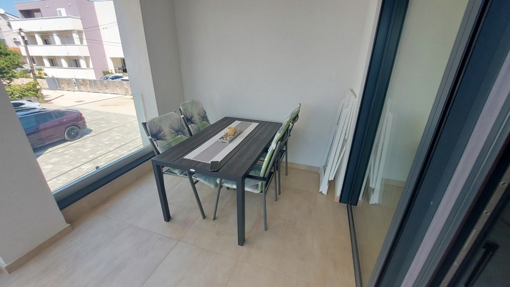 Fedett terasz és kilátás az A3448-as ingatlan parkolójára.