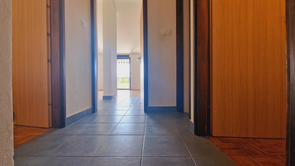 Csempézett folyosó, ajtók a hálószobákba és a nappaliba.
