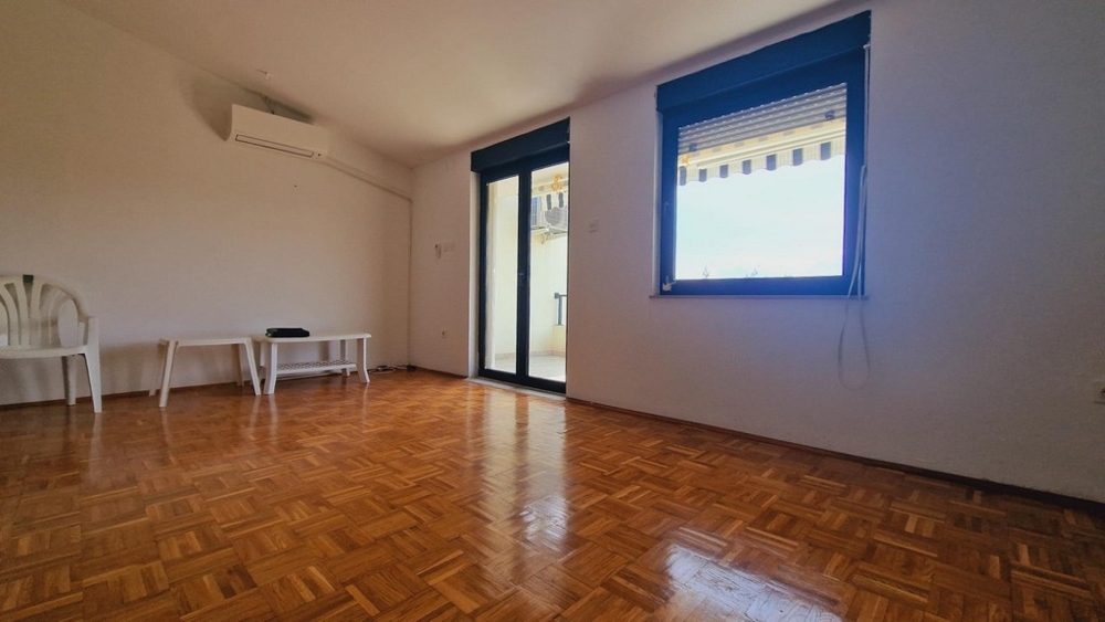 Világos nappali parkettával, kijárattal a teraszra, nagy ablakokkal.