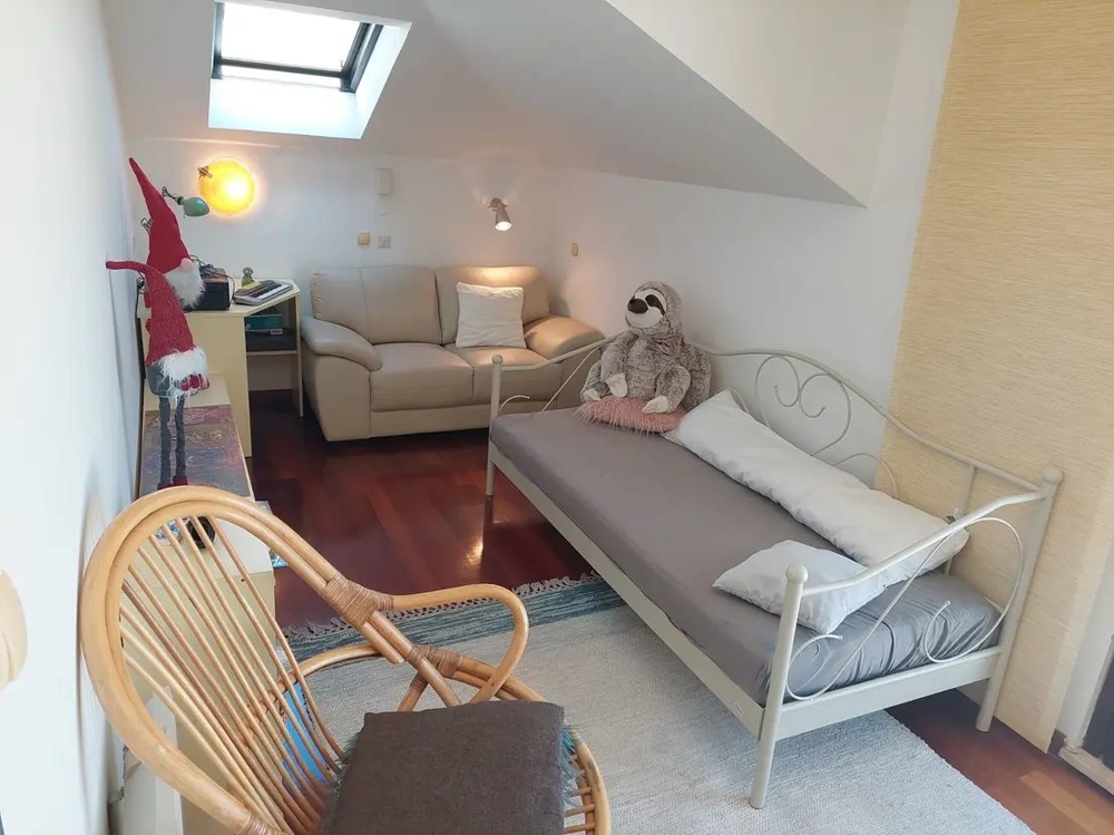 Szoba kanapéval, tetőablakkal, ággyal és dekorációval